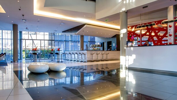 Eine moderne Lobby mit Bar, Sitzgelegenheiten und einer Glaskuppel.