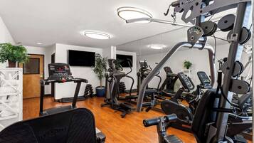 A modern gym with various exercise equipment, including treadmills, elliptical machines, and weight machines.