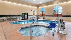 A hotel swimming pool area with multiple pools, lounge chairs, and a water slide. - Best Western Moriarty Heritage Inn (Moriarty)
