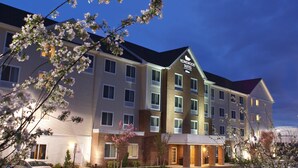 A multi-story hotel with a prominent "Homewood Suites" sign, featuring a brick facade and multiple windows.