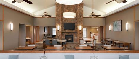 A spacious lobby with a stone fireplace, multiple seating areas, and ceiling fans.