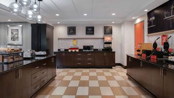 A modern kitchen with checkered flooring, dark cabinetry, and a central island.