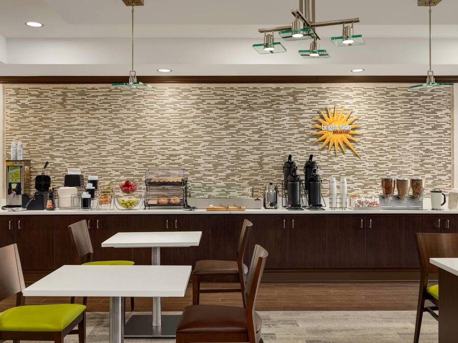 Una cocina moderna con protector contra salpicaduras de piedra, un letrero luminoso y una barra desayunadora.