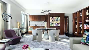 A modern living room with a dining area, a kitchen, and a view of the city.