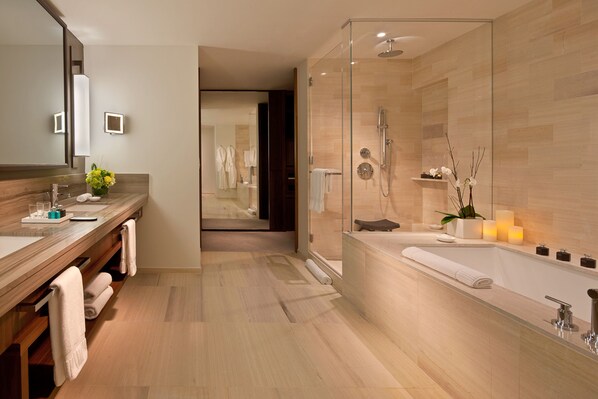 A modern bathroom with a glass-enclosed shower, a large mirror, and a wooden vanity.