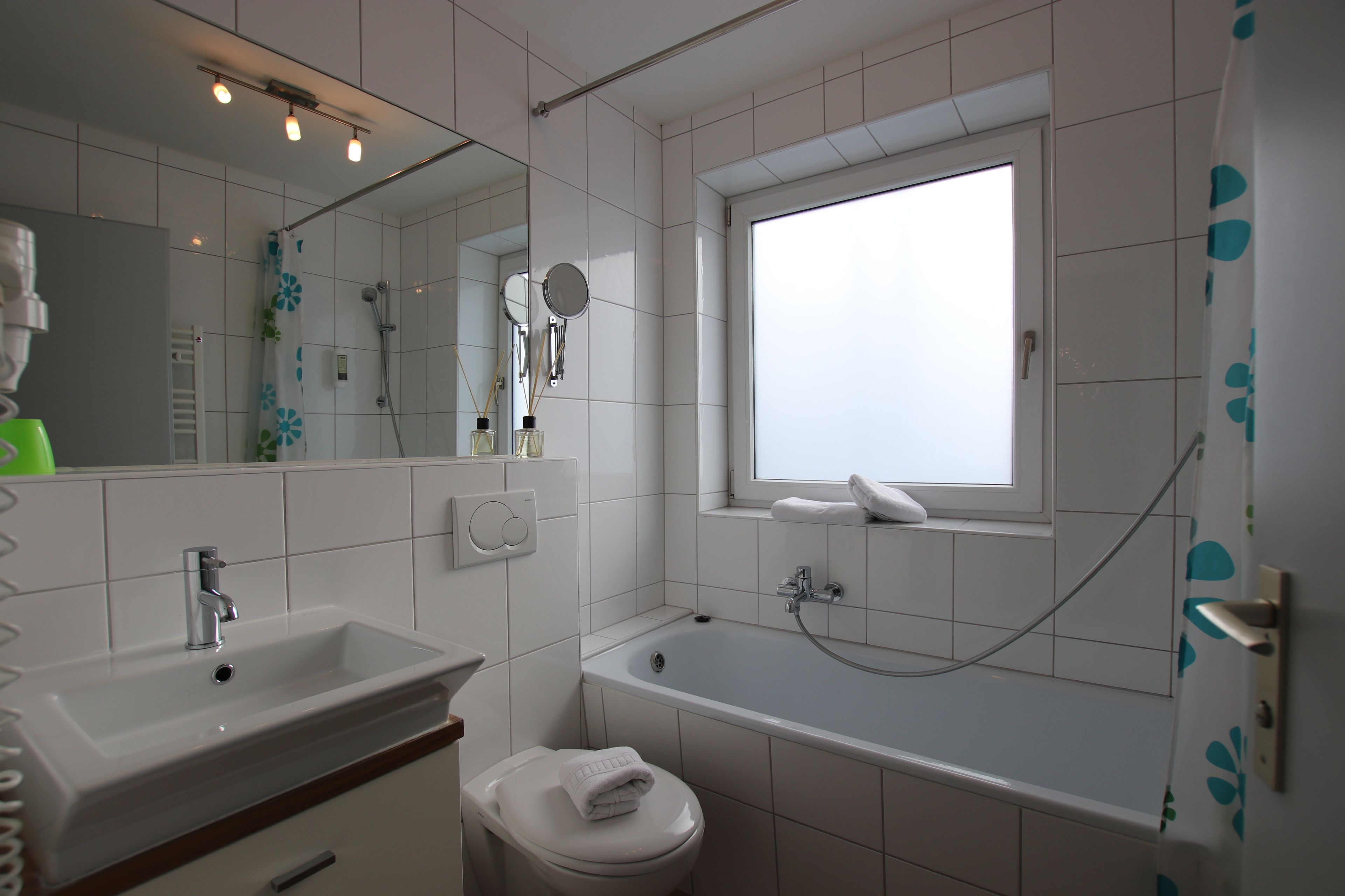 Un baño con lavamanos, inodoro y bañera.