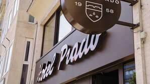 Ein Hotelschild mit dem Schriftzug 'HOTEL PRADO 19 58' und einem Wappen.