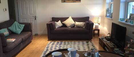 A living room with a sofa, coffee table, and a painting on the wall.