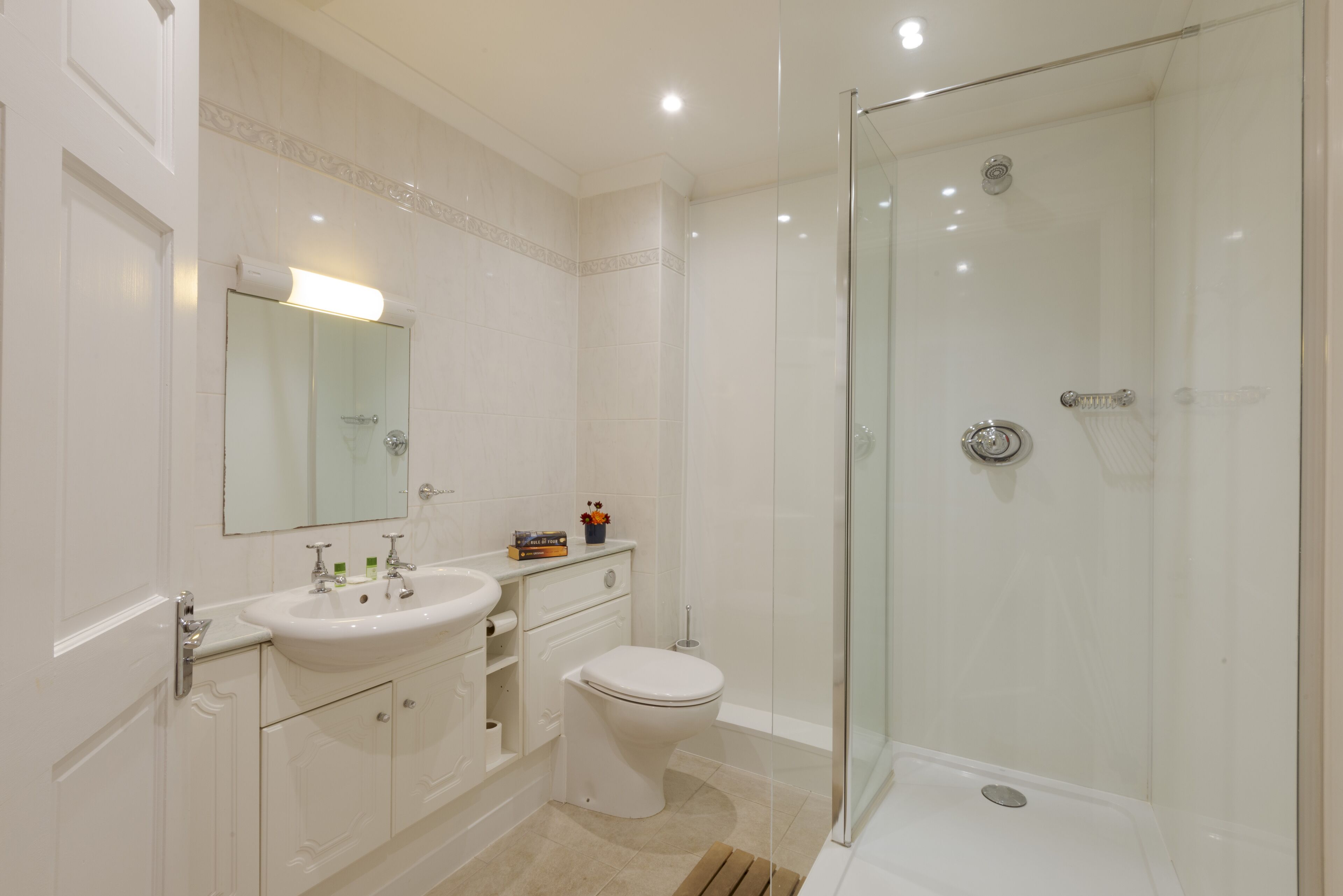 Une salle de bain moderne avec une douche à parois de verre, un lavabo blanc et des toilettes.