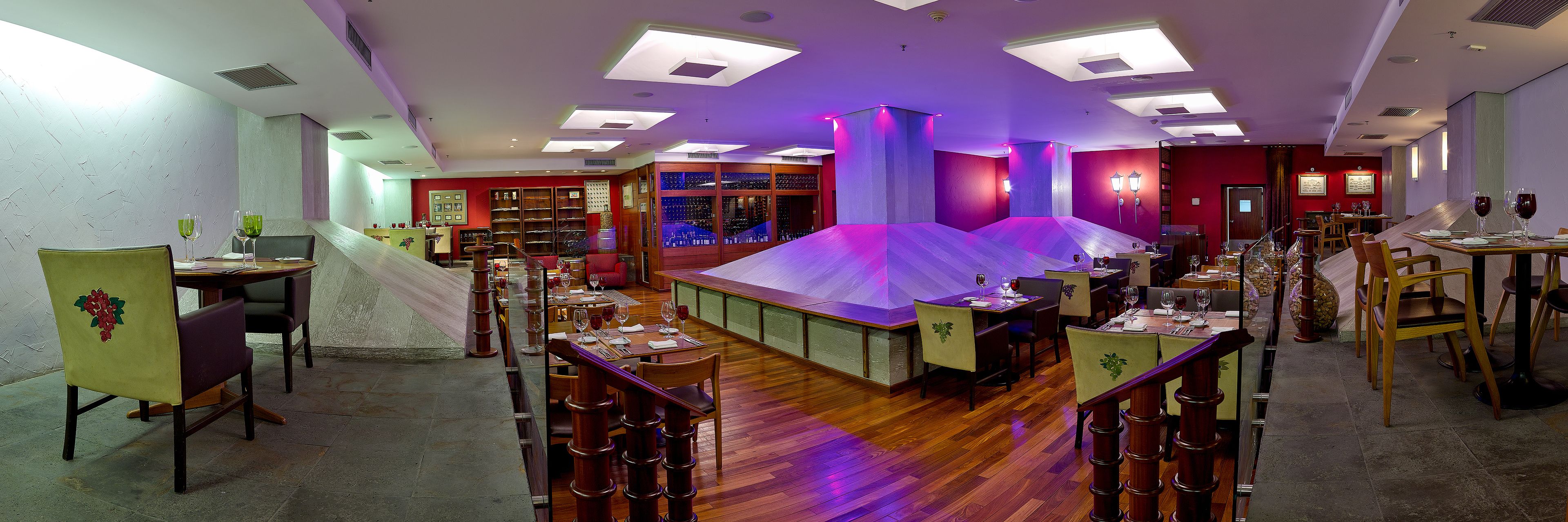 A restaurant with multiple dining areas, wooden floors, and a variety of seating arrangements.