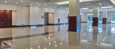 A spacious lobby with polished tile floors, recessed lighting, and a clear view of the exit.