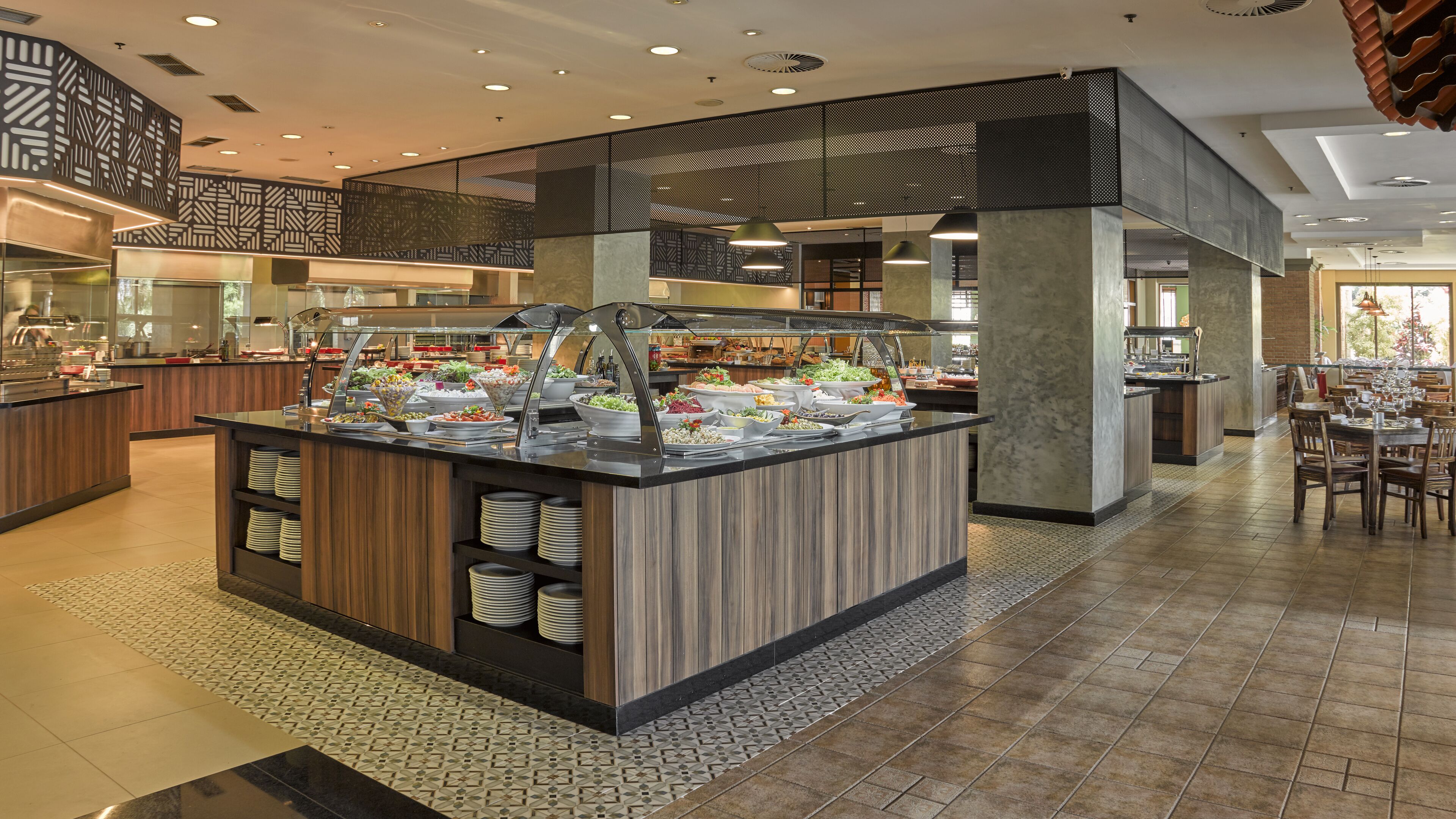 A buffet area with various food stations and a seating area with tables and chairs.