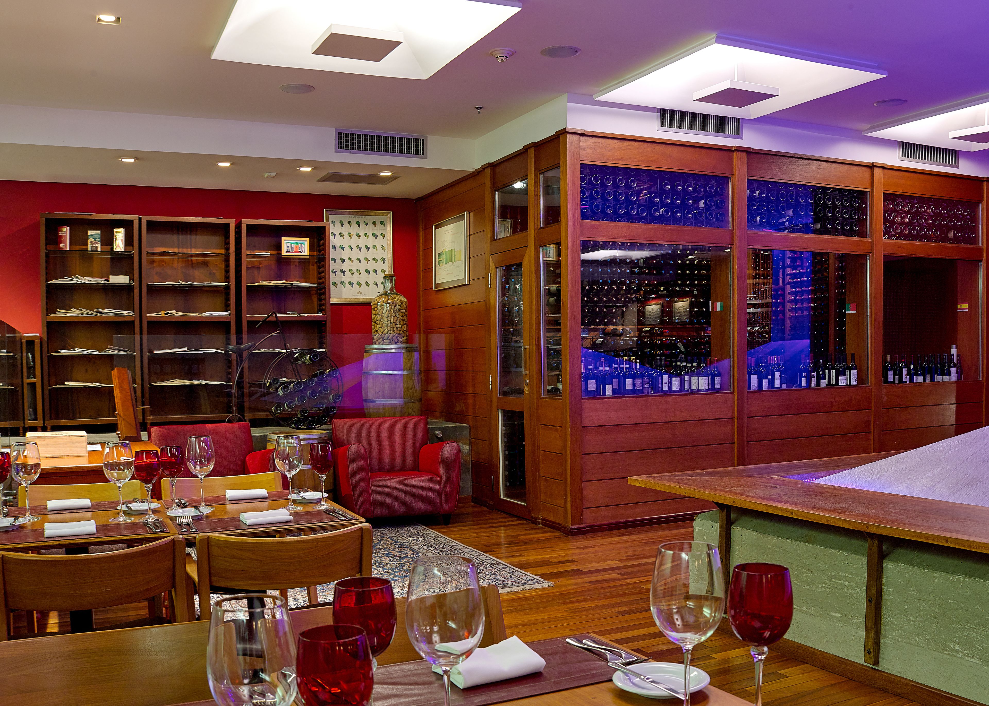 Un restaurant avec des meubles en bois, des verres à vin et un présentoir à bouteilles.