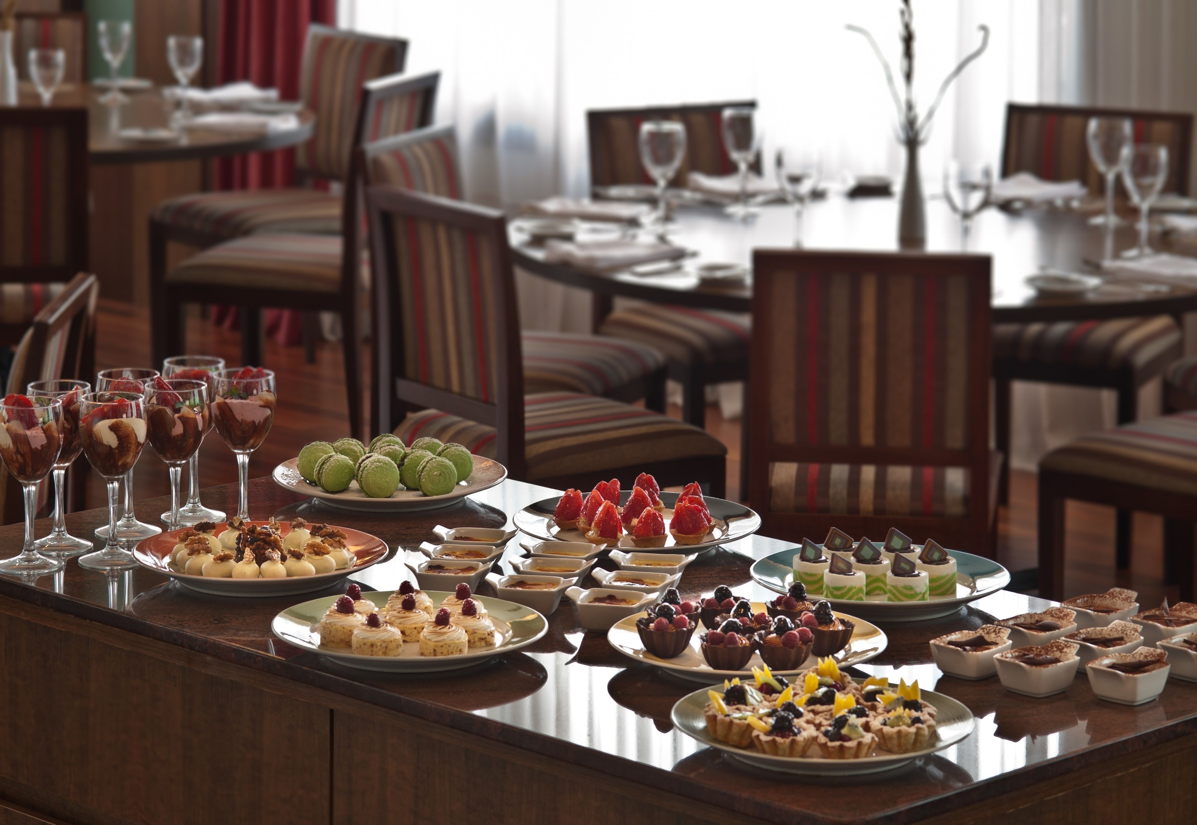 A buffet table with various desserts and beverages.