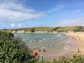 A coastal beach scene with people engaging in various activities. - Porth Veor Villas & Apartments (Newquay)