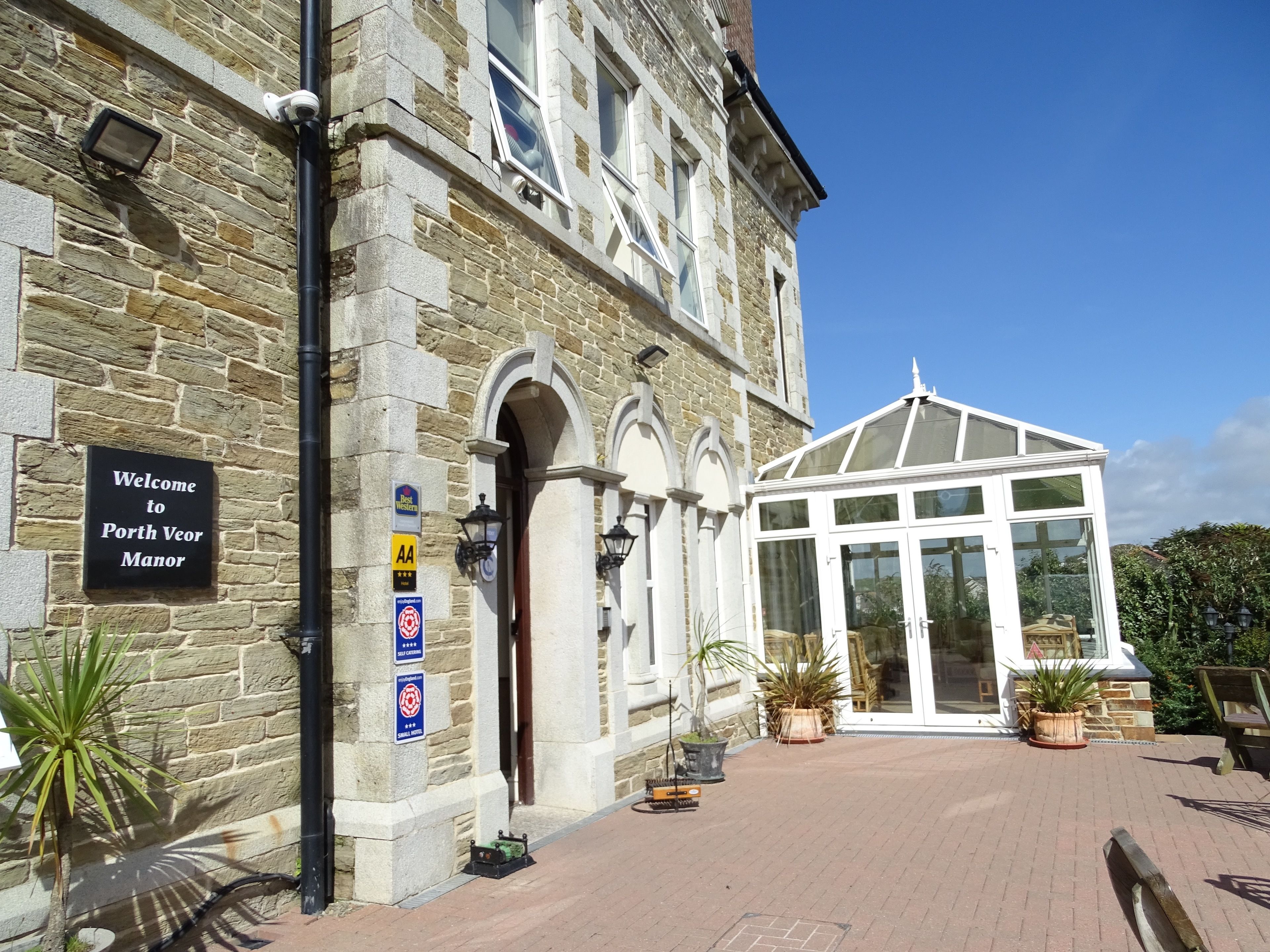 A stone building with a sign reading "Welcome to Porth Veor Manor."