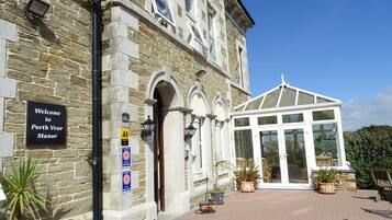 A stone building with a sign reading "Welcome to Porth Veor Manor."