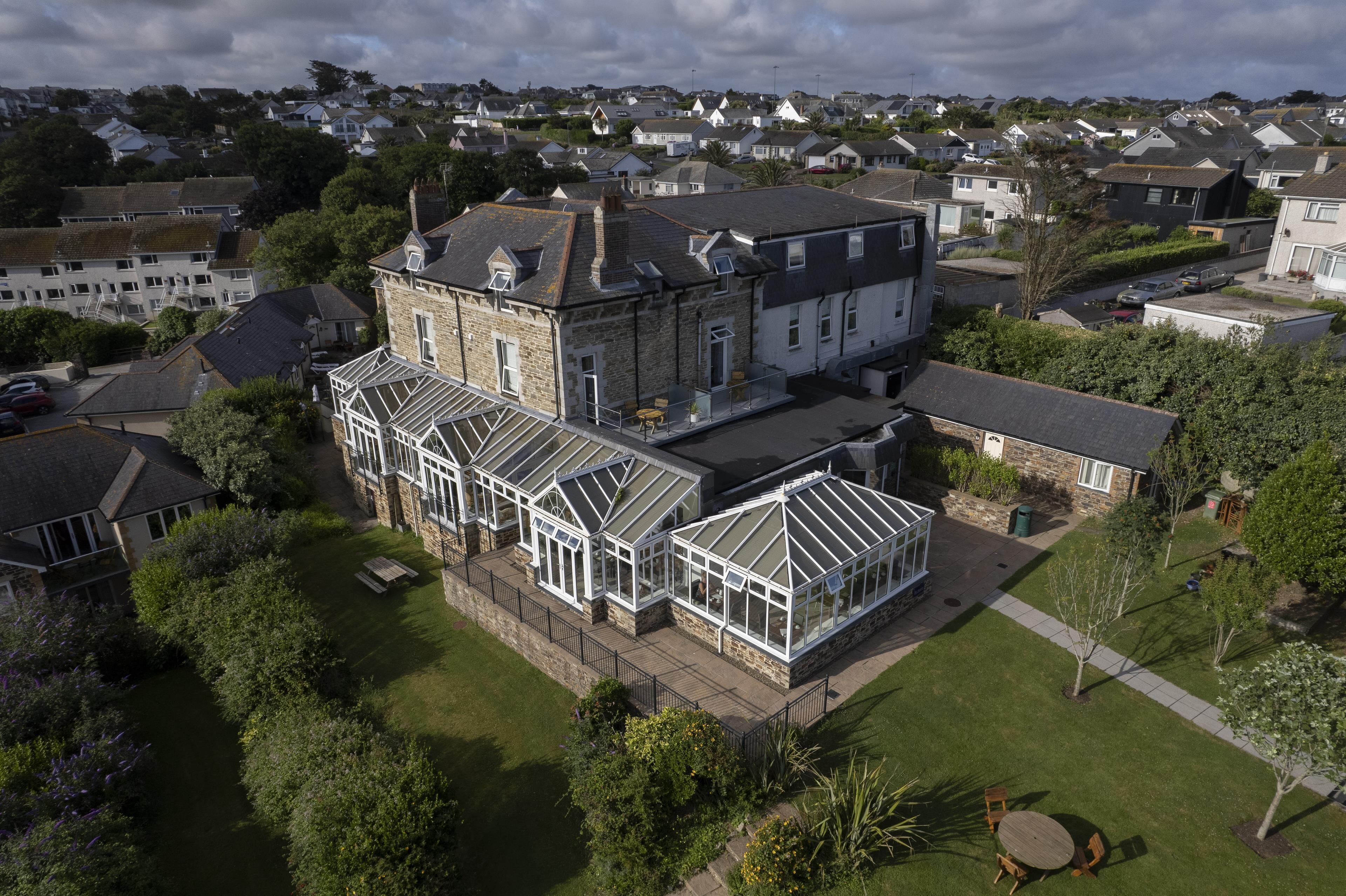 A large house with a spacious garden, multiple rooms, and a conservatory.