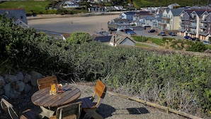 A coastal town with a beach, residential buildings, and a dining area with outdoor seating. - Porth Veor Manor, Sure Hotel Collection by Best Western (Newquay)