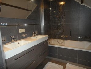 A modern bathroom with two sinks, a bathtub, and a shower. - B&B Ter Gracht (Wevelgem)