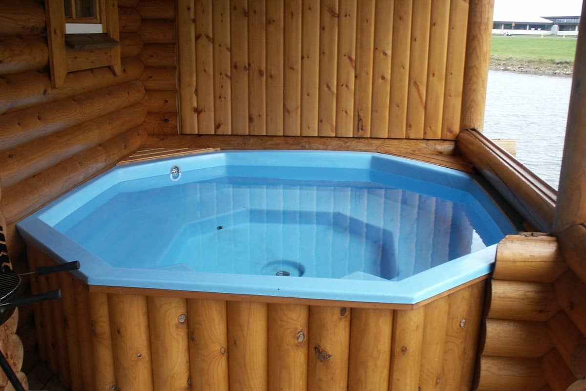 Une cabane en bois avec un bain à remous.