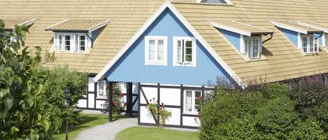 A traditional building with a steeply pitched roof, dormer windows, and a symmetrical facade.