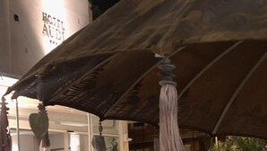 Un espace piscine avec une eau d’un bleu limpide, un coin salon couvert agrémenté de parasols et un escalier menant à un niveau supérieur.