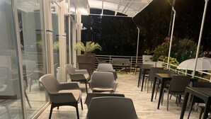 Un espace extérieur aménagé avec des meubles modernes et une petite table agrémentée d’une plante.