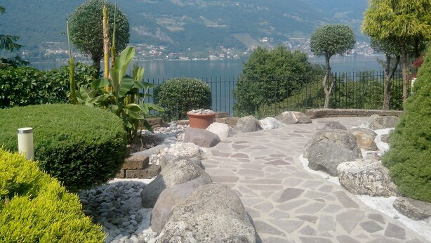 A stone pathway leading to a scenic overlook with a lake and mountains in the background. - Empire Resort (Iseo)
