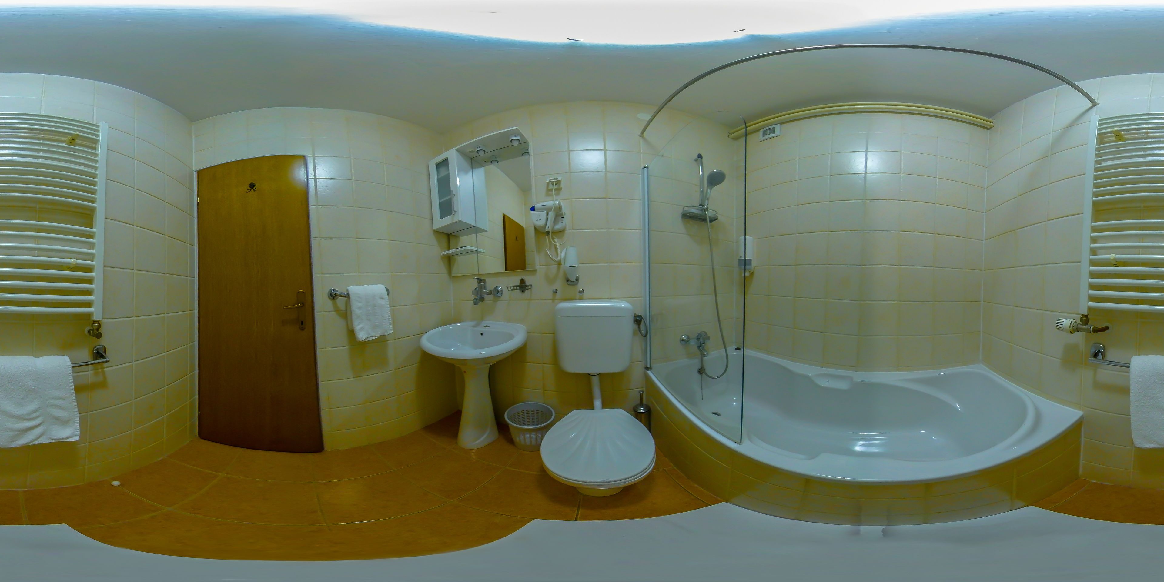 Un baño con bañera, inodoro, lavamanos y ducha.