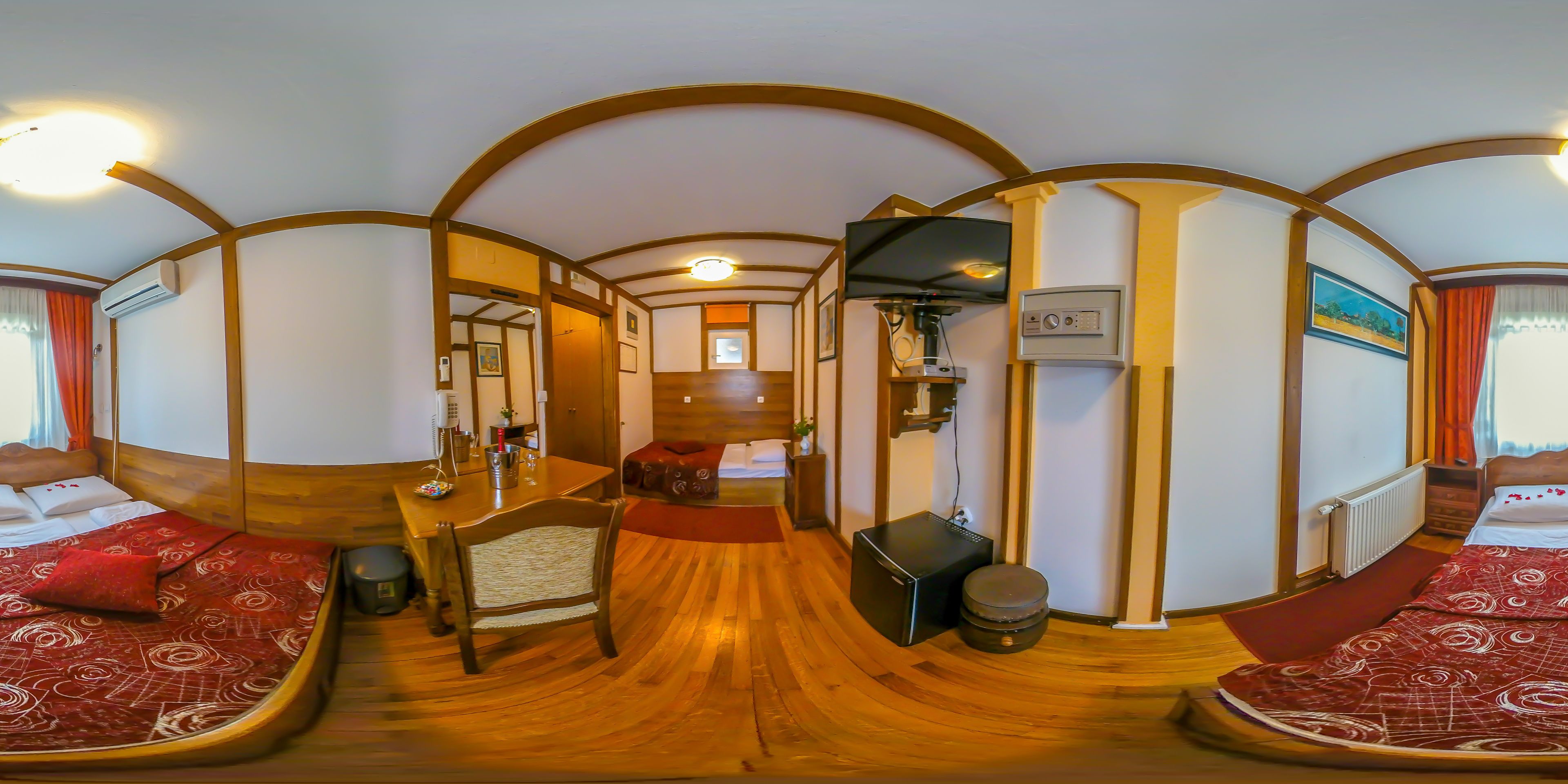 A room with a bed, a desk, a chair, a television, and a radiator.