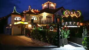 A building with a sign reading "Garten" and a well-lit entrance. - Hotel Garten (Slavonski Brod)