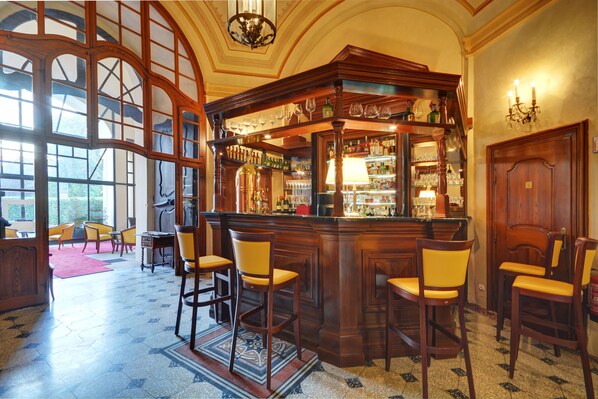 A bar area with wooden bar counter, multiple chairs, and a large window with a view.