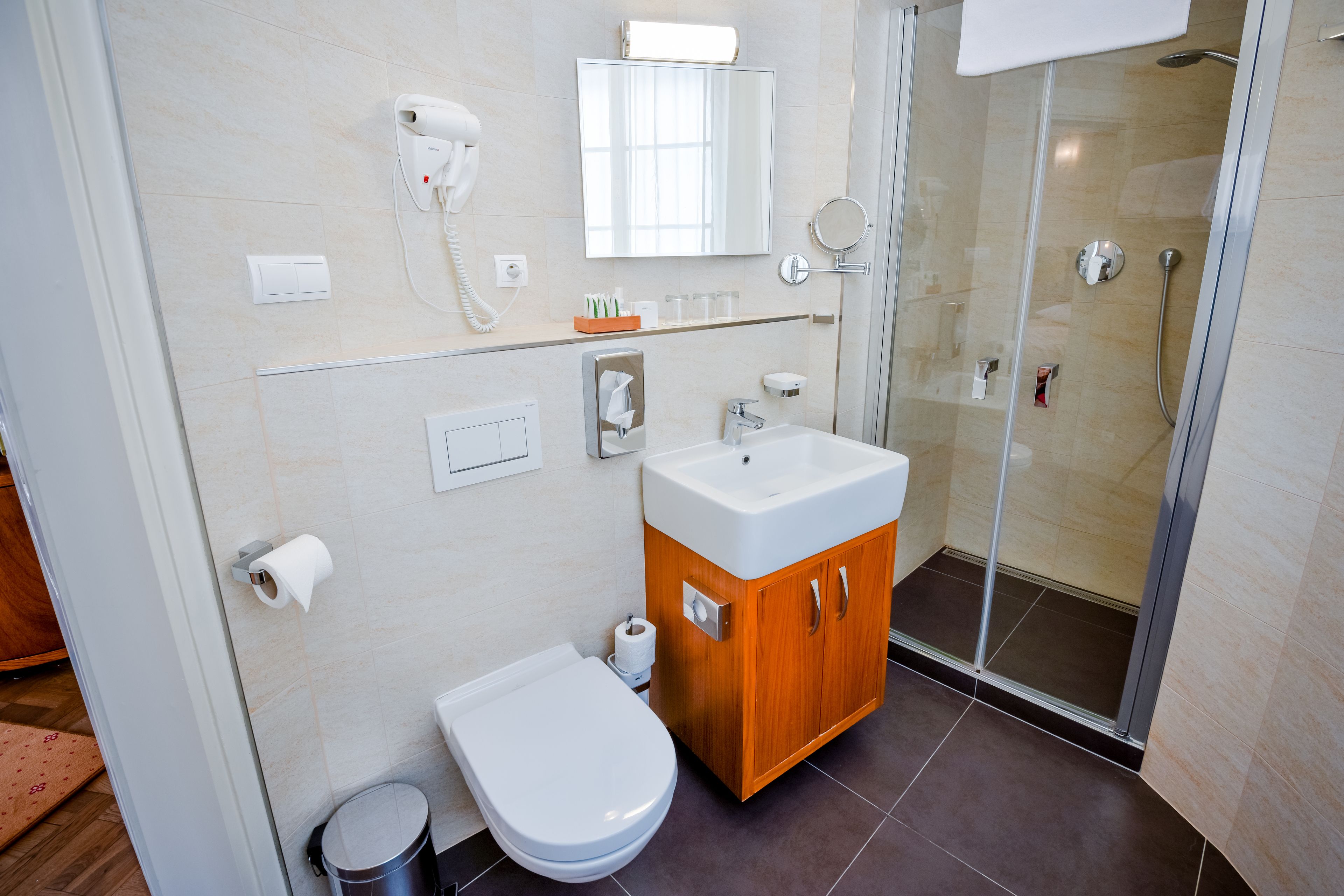 A modern bathroom with a toilet, sink, and shower.