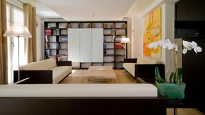Una sala de estar moderna con un sofá, una mesa de centro y una estantería llena de libros.