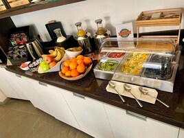 Mostrador de buffet con diversos alimentos y salsas.