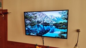 Seinälle asennettu televisio, jossa näkyy kaunis vuoristojärvi.