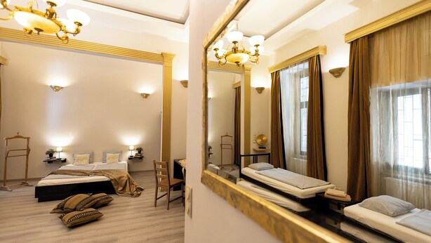 A hotel room with a large bed, a desk, a chair, and a mirror. - Friends Hostel and Apartments Budapest (Budapest)