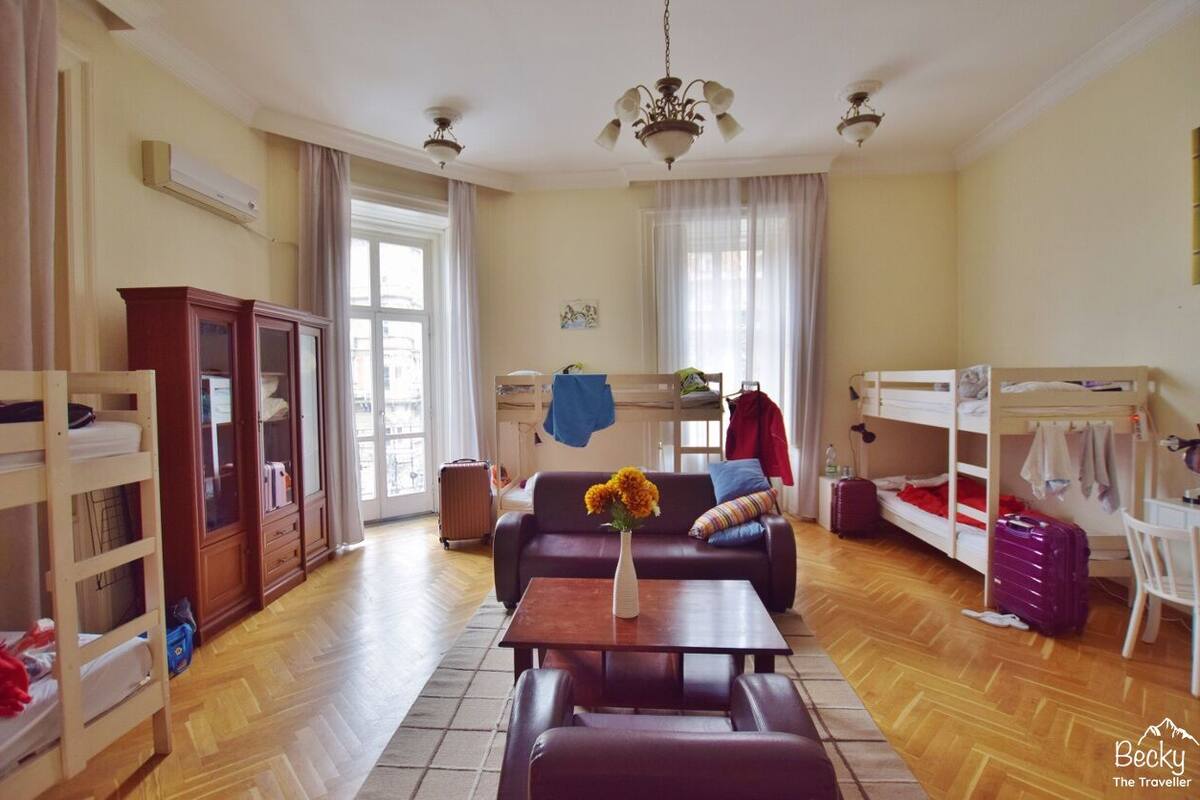 A spacious living room with a sofa, a coffee table, a wooden cabinet, and a bunk bed.