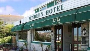 The exterior of the Pendeen Hotel with a green awning and potted plants in front. - Pendeen Hotel (Newquay)