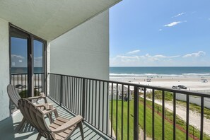 Uma varanda com vista para a praia e o oceano.