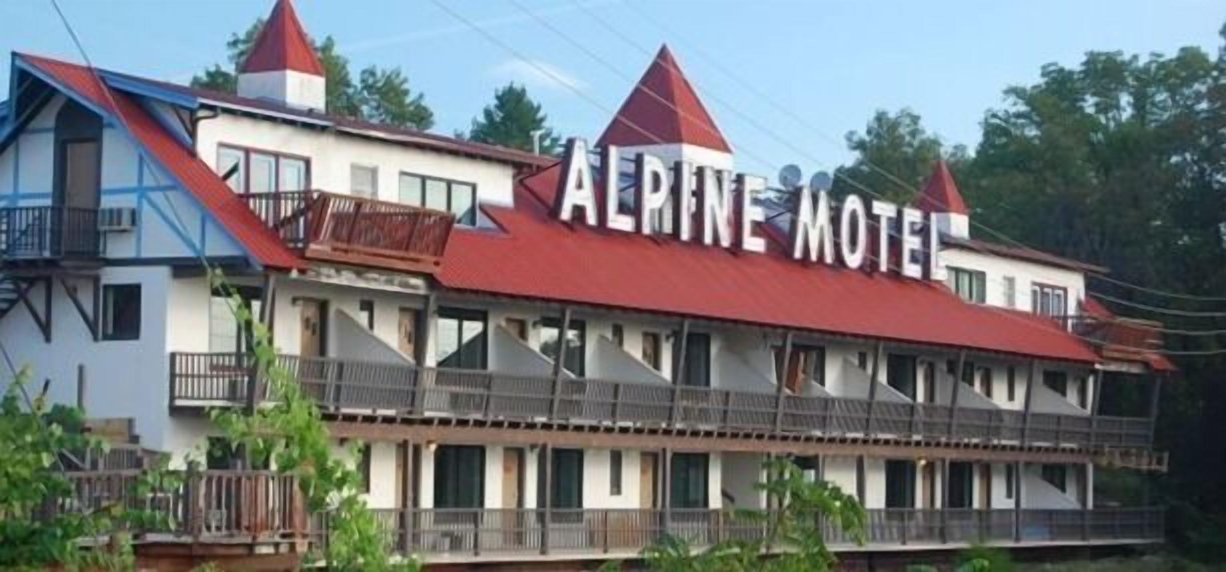 A two-story building with a red roof and balconies, labeled "AERINE MOTEL".