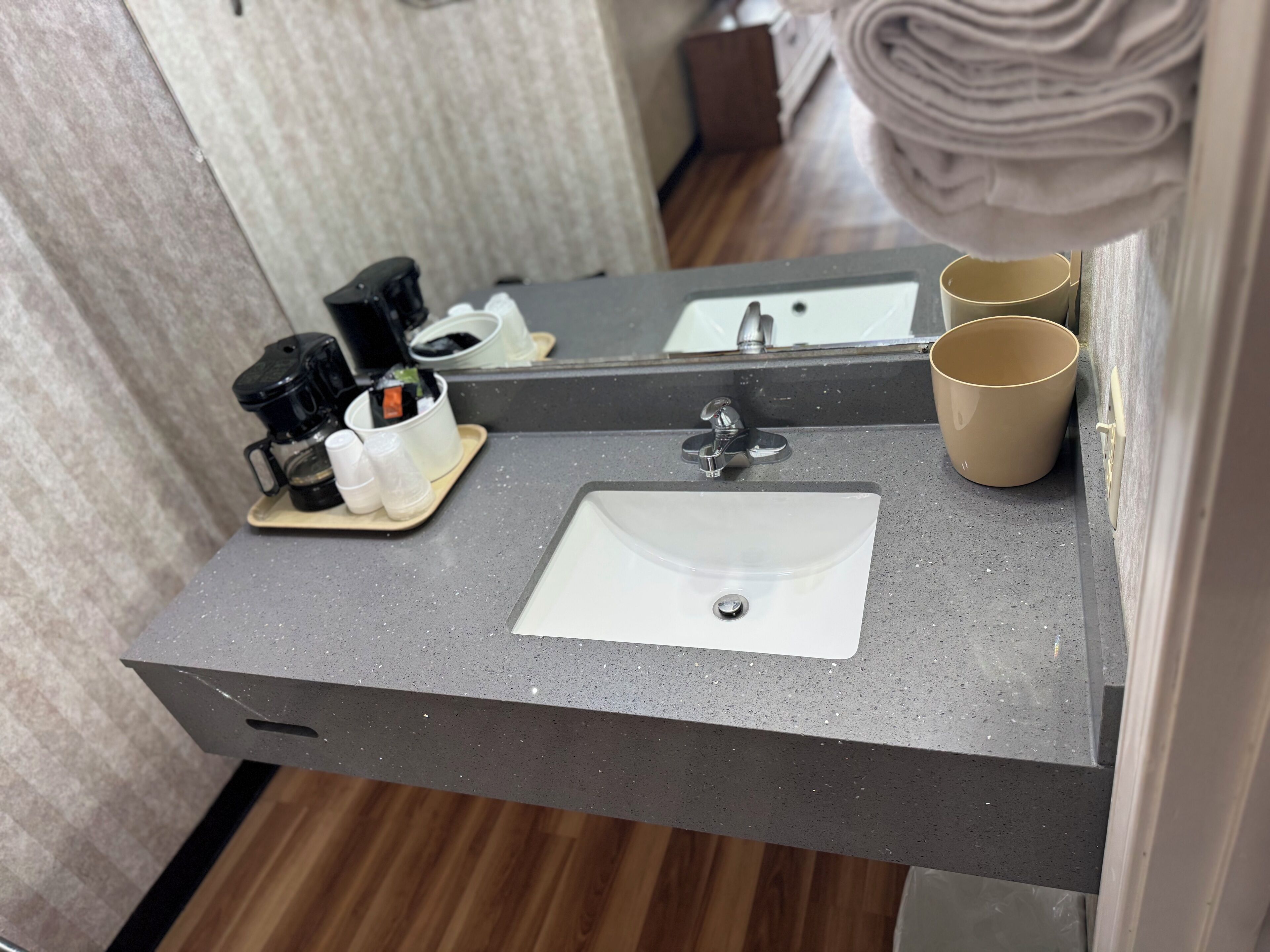 A bathroom with a sink, mirror, and toiletries.