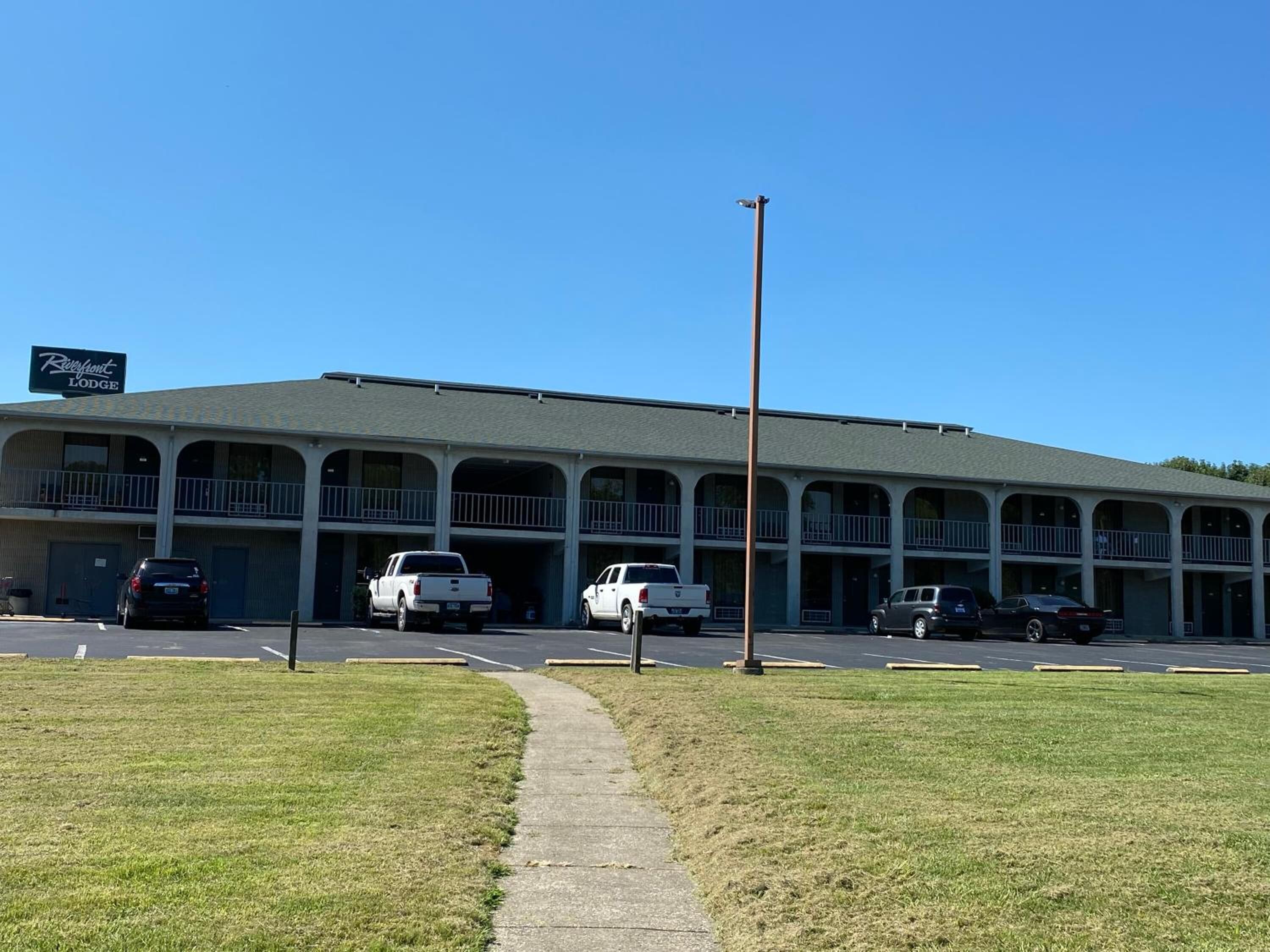 A motel with multiple balconies and a parking lot.