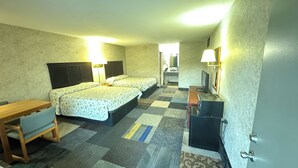 A hotel room with two beds, a desk, a TV, and a bathroom visible through an open door. - Riverfront Lodge (Burkesville)