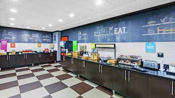 A breakfast area with a checkered floor, a counter with various food items, and a wall with kitchen utensils and food-related drawings.