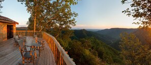 A wooden deck with outdoor seating, overlooking a forested valley. - The Lodge at Primland, Auberge Collection (Meadows Of Dan)