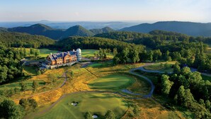 A large estate with a prominent building, expansive green lawns, and rolling hills in the background. - The Lodge at Primland, Auberge Collection (Meadows Of Dan)