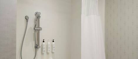 A bathroom with a bathtub, shower, and a curtain.