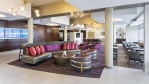 A spacious lobby with a modern sofa, multiple seating areas, and a bar. - SpringHill Suites Philadelphia Airport Ridley Park (Ridley Park)